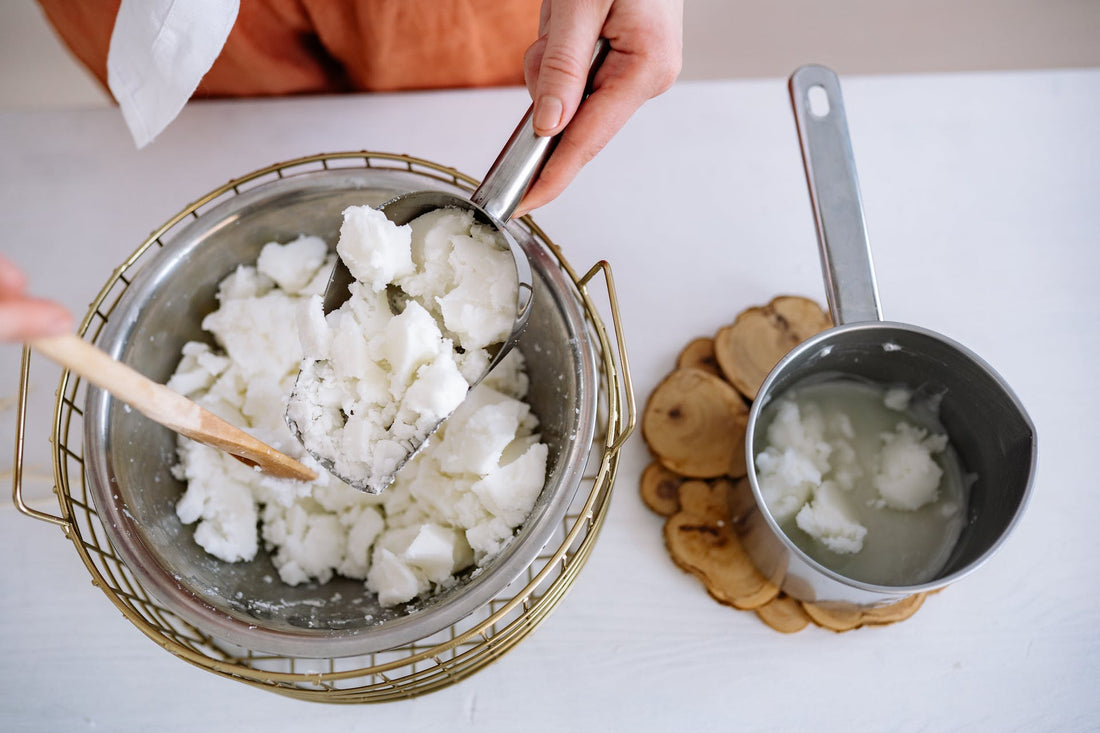 One bowl filled with solid coconut wax chunks and the other willed with melted coconut wax.